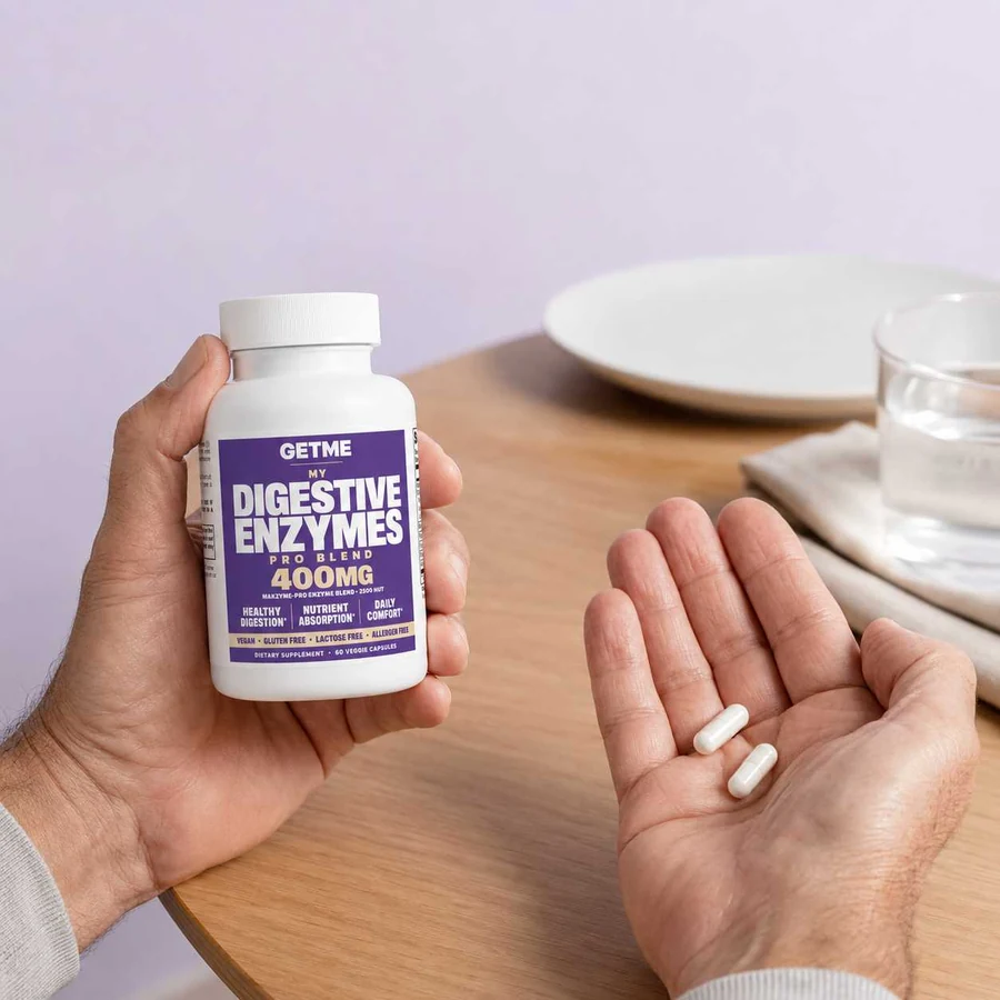 Man holding a bottle of Getme Digestive Enzymes Pro Blend in a kitchen